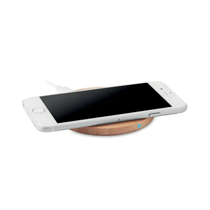 Un telefon alb elegant se odihneste pe un incarcator wireless rotund din bambus 10w cu lumina albastra indicator