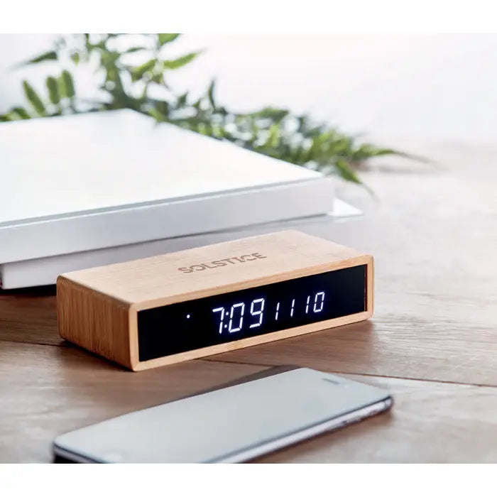 Un ceas alarmă digital din bambus cu afișaj led albastru și încărcător wireless de 5w integrat