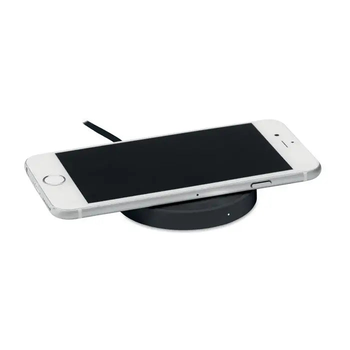 Iphone argintiu odihnindu-se pe un incarcator wireless mic de 5w negru rotund