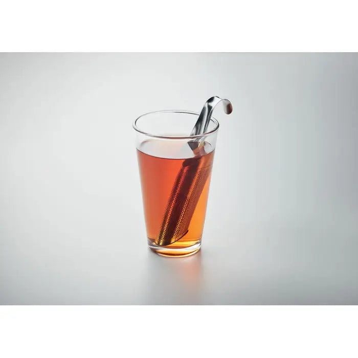 Infuzor de ceai din otel inoxidabil cu maner curbat si corp perforat in lichid de culoare chihlimbar