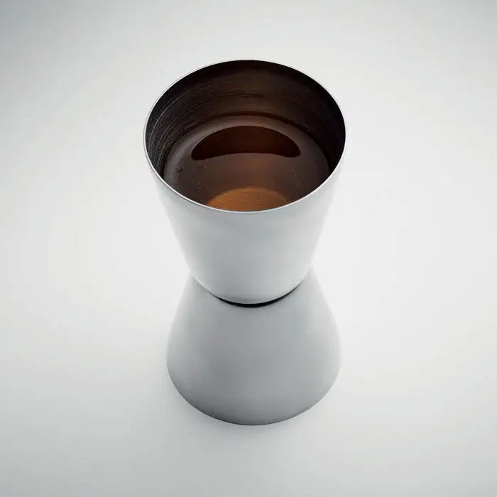 Jigger din otel inoxidabil elegant cu doua parti, umplut cu lichid ambrat, perfect pentru masurarea bauturilor