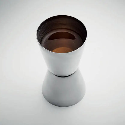 Jigger din otel inoxidabil elegant cu doua parti, umplut cu lichid ambrat, perfect pentru masurarea bauturilor