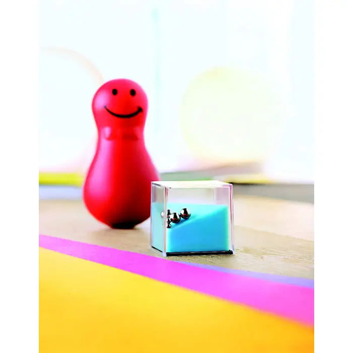 Cub transparent umplut cu lichid albastru si trei sfere metalice pentru jocuri puzzle asortate