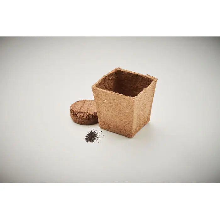 Kit de cultivare cu seminte de menta in ghiveci biodegradabil patrat maro cu capac rotund din pluta si seminte negre raspandite