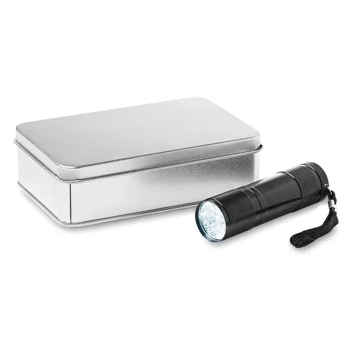 Lanterna cu LED neagra cu grip texturat si bratara, alaturi de o cutie metalica argintie
