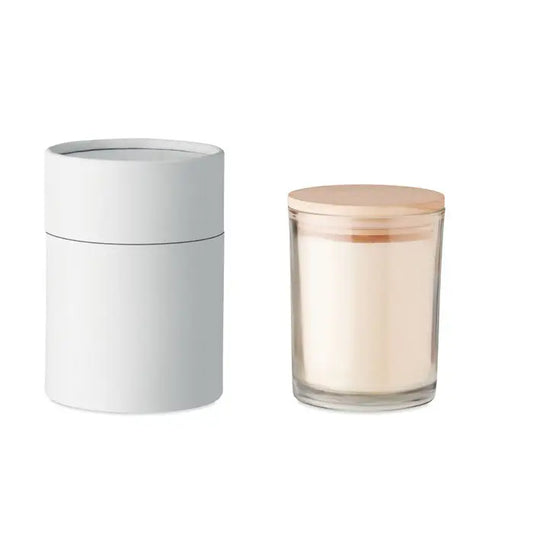 Lumanare cu parfum de vanilie in borcan minimalist din sticla cu capac de lemn deschis si ceara alba cremoasa langa ambalaj cilindric alb