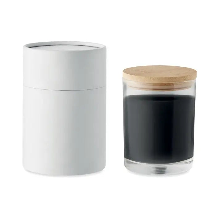 Borcan transparent cu capac din lemn deschis plin cu zat de cafea si recipient alb cilindric pentru lumanare cu parfum de vanilie