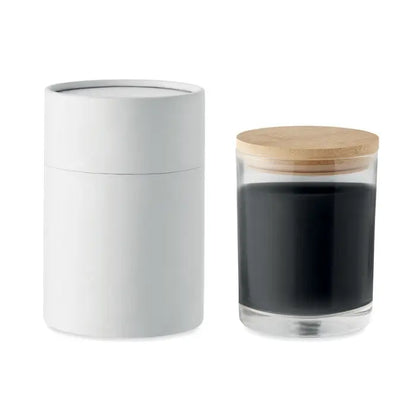 Borcan transparent cu capac din lemn deschis plin cu zat de cafea si recipient alb cilindric pentru lumanare cu parfum de vanilie