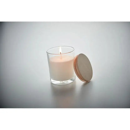 Lumanare cu parfum de vanilie crem alb aprins in borcan de sticla transparent cu capac rotund din lemn