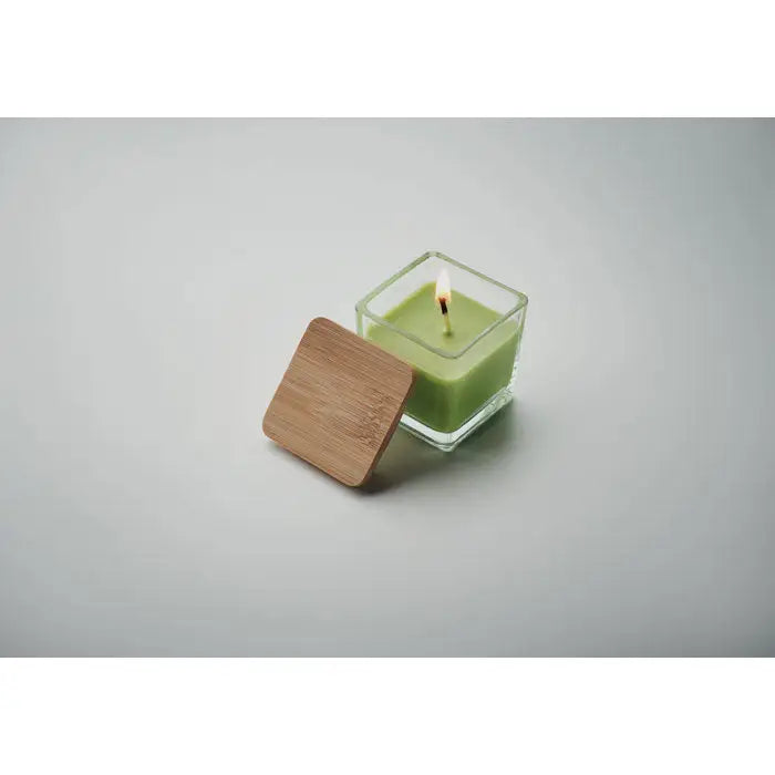 Lumanare parfumata patrata 50gr cu ceara verde vibranta si capac din bambus, aprinsa in recipient de sticla transparenta