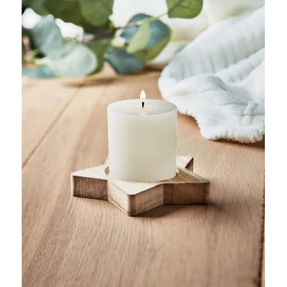Lumanare alba cilindrica asezata pe un suport din lemn in forma de stea pentru decor ambiental