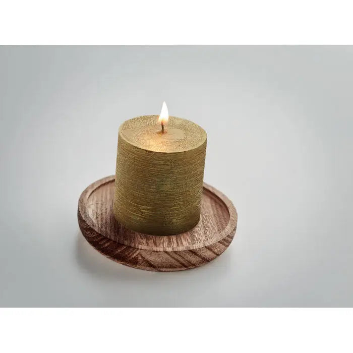 Lumanare aurie texturata aprinsa pe baza rotunda din lemn pentru decor interior elegant