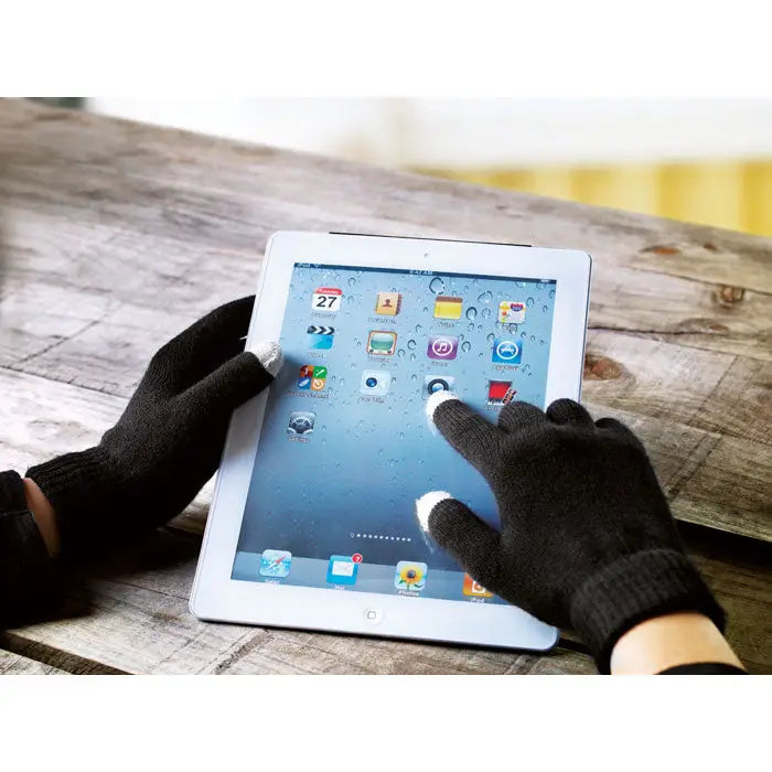 Manusi tactile pentru smartphone-uri negre cu degete decupate folosite pe un tablet alb cu ecran tactil si data 27