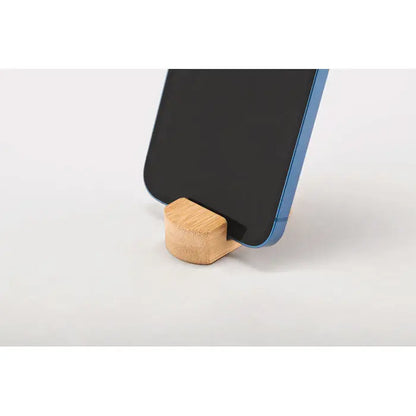Mini suport pentru telefon din bambus maro deschis tinand un smartphone albastru