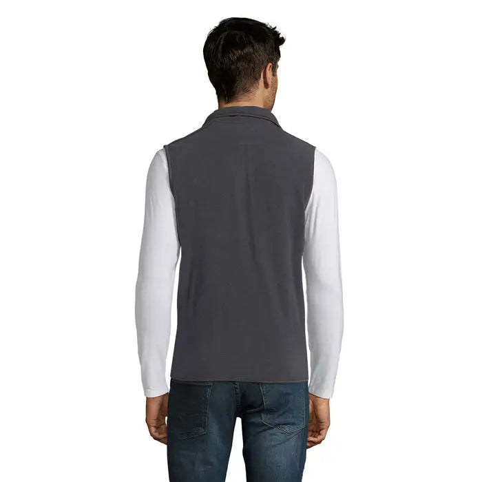 Vestă fleece norvegia unisex gri purtată peste o cămașă albă cu mâneci lungi din material fleece moale