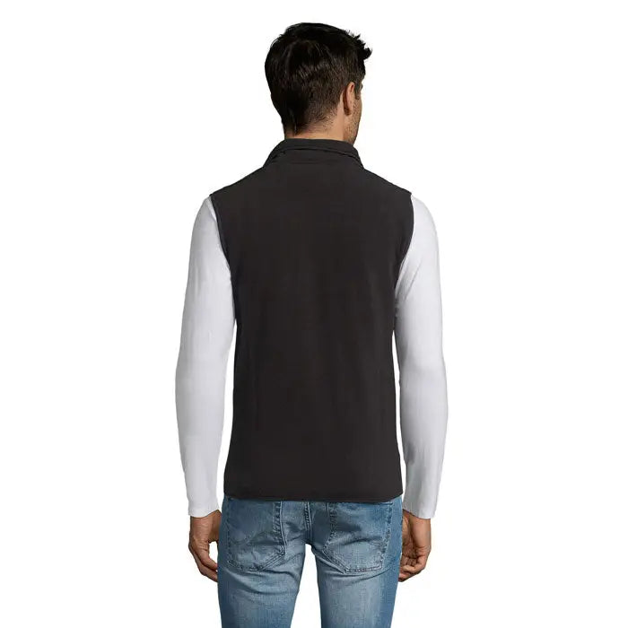Neagră vestă fleece norvegia unisex purtată peste o cămașă albă cu mâneci lungi din fleece