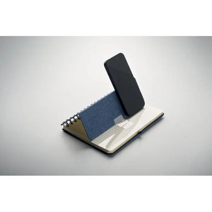 Notebook a5 albastru texturat cu spirală și suport pentru telefon, telefon negru pe paginile deschise