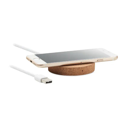 Gold-colored smartphone on a circular cork wireless charging pad with 10w power and white usb cable nearby