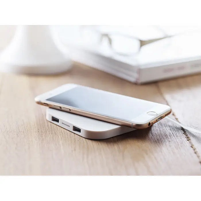 Pad de incarcare wireless 5w alb elegant cu doua porturi usb sub un telefon auriu