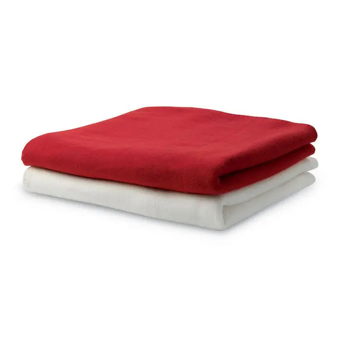 Patura din lana rosie din fleece moale pliata ordonat peste o patura alba din lana