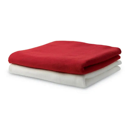 Patura din lana rosie din fleece moale pliata ordonat peste o patura alba din lana