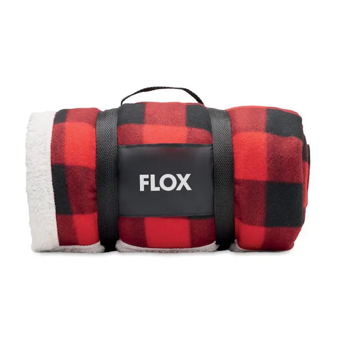 Patura din lana rpet sherpa cu model rosu si negru in carouri si captuseala alba sherpa, rulata si fixata cu bretea flox