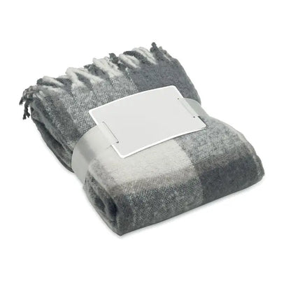 Patura mohair în carouri gri și alb cu margini franjurate, ideală pentru decor și confort acasă
