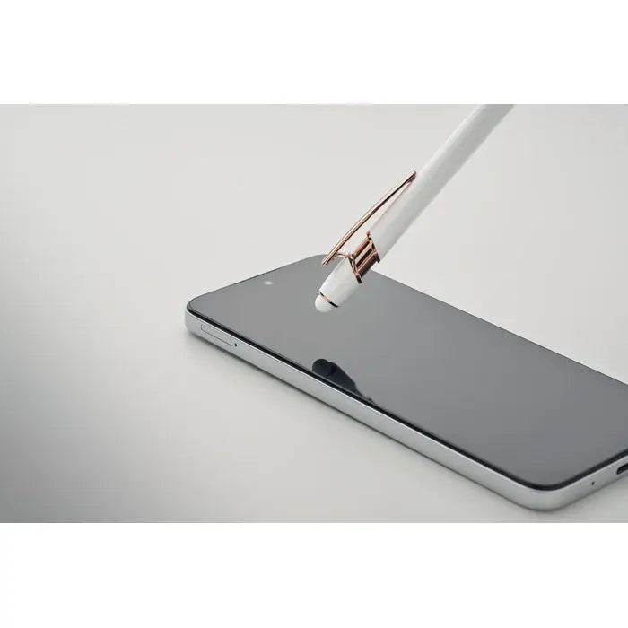 Pix din aluminiu reciclat alb cu clip roz auriu sprijinit pe un smartphone argintiu