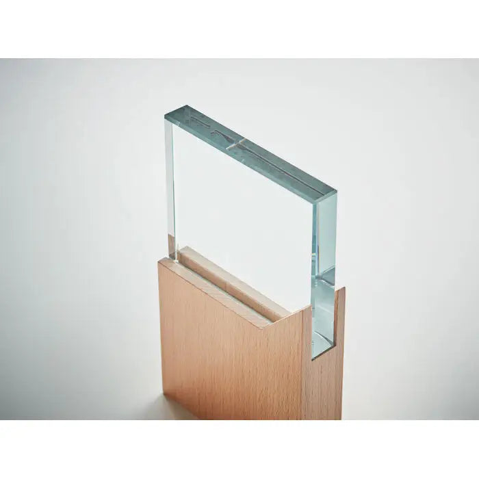 Placa cu premiu din sticla transparenta cu suprafata neteda si margini precise, pe suport din lemn deschis