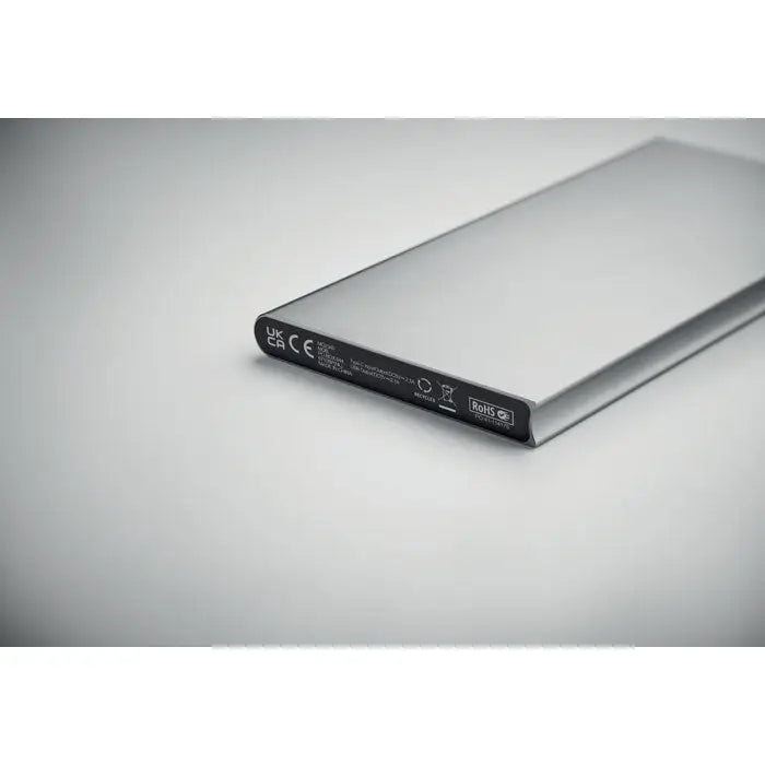 Power bank 8000 mAh portabil dreptunghiular argintiu cu finisaj metalic lucios și etichetă neagră pe margine