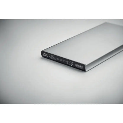 Power bank 8000 mAh portabil dreptunghiular argintiu cu finisaj metalic lucios și etichetă neagră pe margine