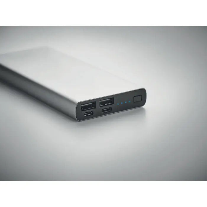 Power bank portabil argintiu dreptunghiular de 10000 mah cu multiple porturi usb și luminile indicator led