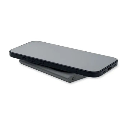 Smartphone negru odihnindu-se pe un incarcator wireless mat cu aspect elegant pentru power bank incarcator wireless