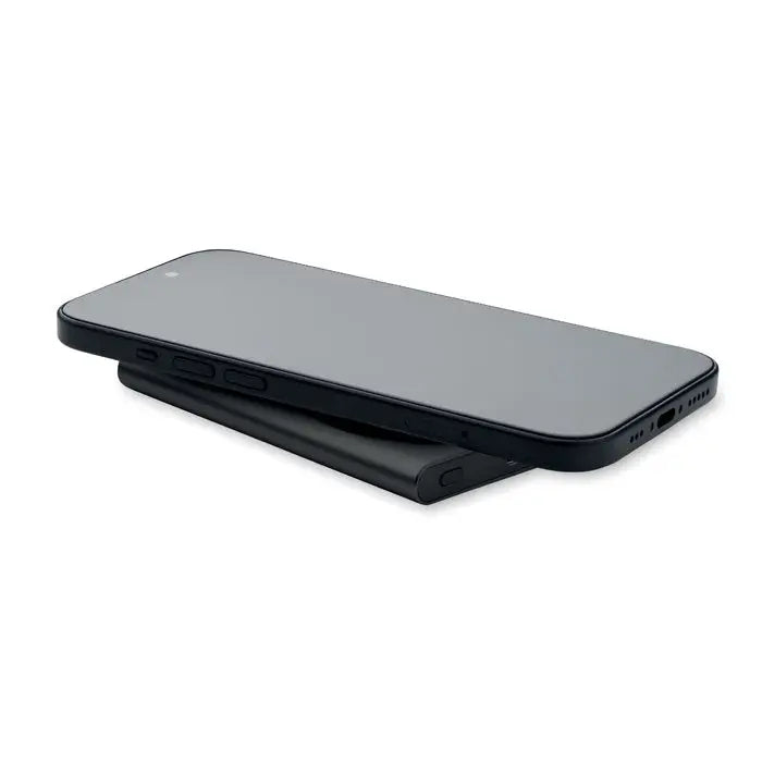 Power bank incarcator wireless negru cu telefon smart negru așezat pe suportul de încărcare wireless