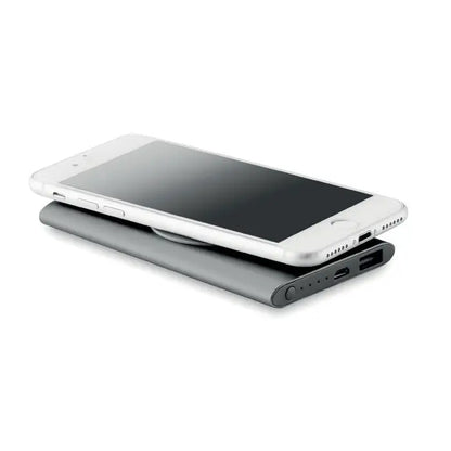Iphone argintiu așezat pe un power bank wireless 4000mAh negru mat cu porturi usb și lumini indicatori vizibile