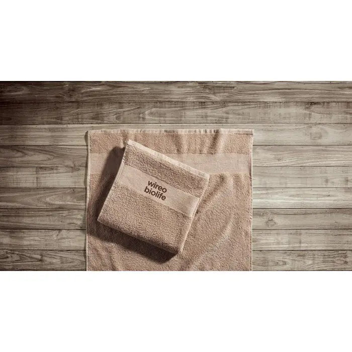 Set de prosoape bumbac organic bej 100x50cm cu branding wireo biolife pe suprafata de lemn