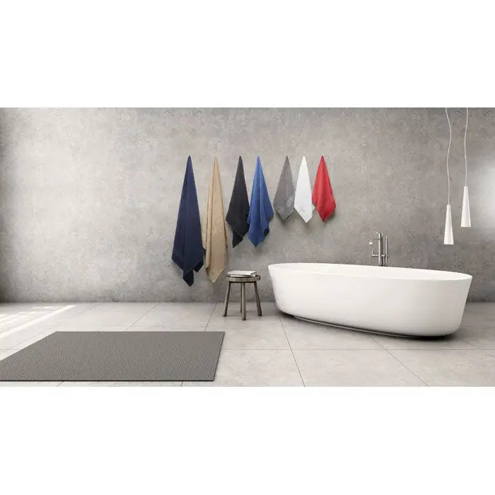 Prosop bumbac organic 180x100cm cu șase prosoape colorate în albastru închis bej negru albastru gri și roșu agățate ordonat pe perete