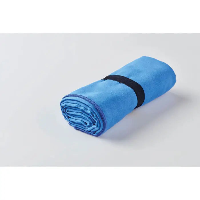 Prosop din microfibra cu doua fete albastru vibrant, rulat si prins cu o banda elastica neagra