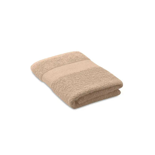Prosop organic 50x30cm beige din bumbac organic cu suprafata texturata si dunga orizontala subtila, pliata ordonat