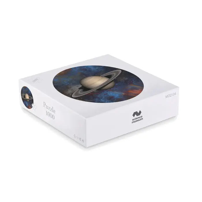 Cutie de puzzle albă și dreptunghiulară cu 1000 piese, imagine circulară a lui saturn pe fundal cosmic roșu și albastru, marca science museum