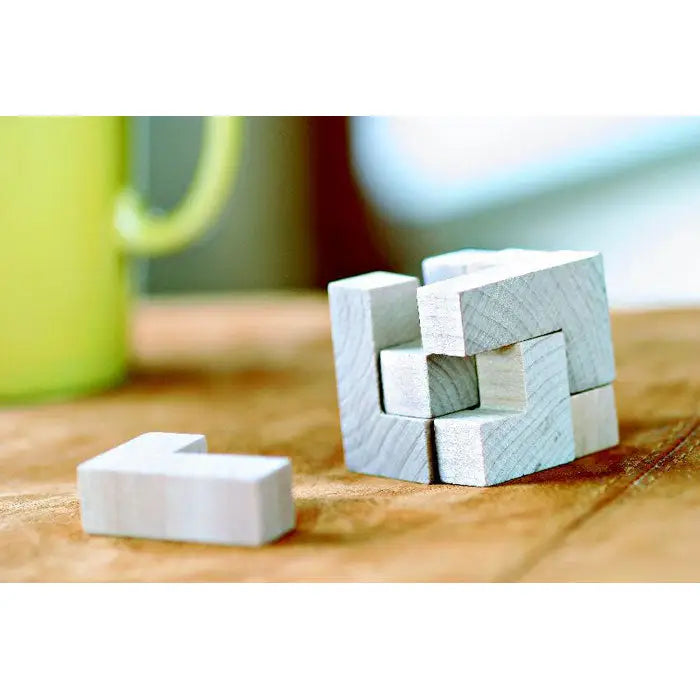 Puzzle din lemn alb cu piese interconectate aranjate geometric în husă de bumbac