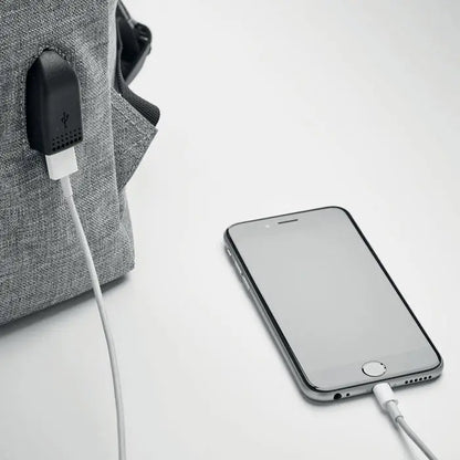 Rucsac din poliester 600d gri cu incarcator usb integrat si iphone 6s argintiu cu cablu alb de incarcare conectat
