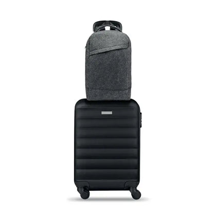 Rucsac pentru laptop de 13 inchi din material texturat gri inchis asezat pe o valiza neagra rigida