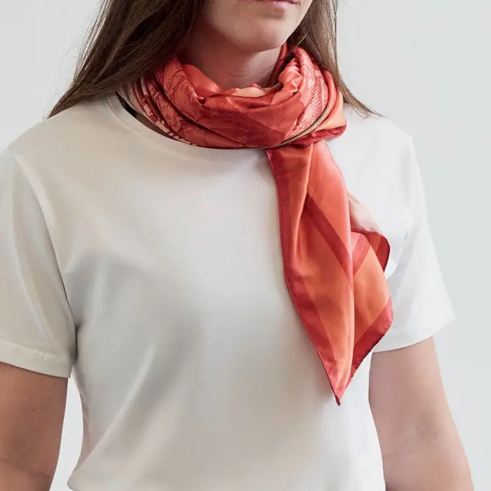 Eșarfă vibrantă coral din mătase reciclata poliester cu model geometric subtil, purtată elegant la gât