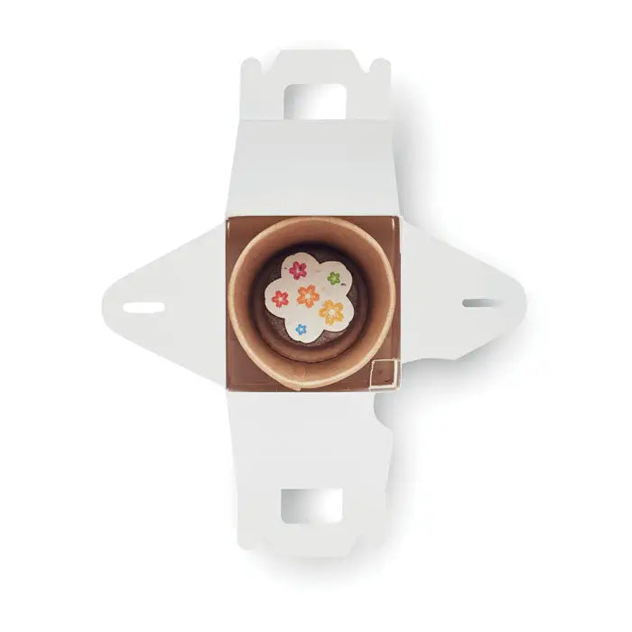 Un mini cupcake de ciocolata cu decoratiuni florale colorate intr-o cutie alba din carton pentru semintele in forma de casa