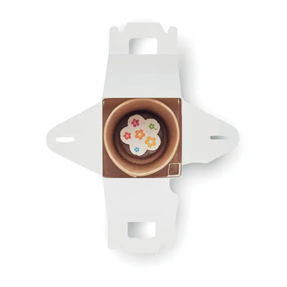 Un mini cupcake de ciocolata cu decoratiuni florale colorate intr-o cutie alba din carton pentru semintele in forma de casa