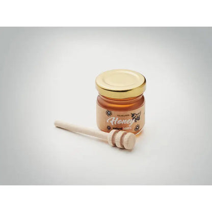 Set borcan cu miere de flori salbatice 50gr cu miere aurie in borcan mic de sticla si capac auriu langa lingurita de lemn