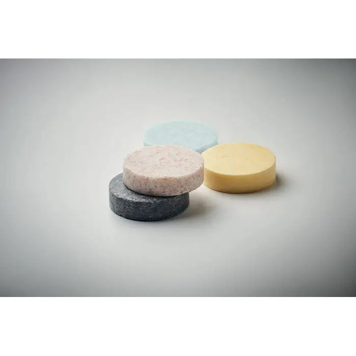 Set cadou vegan de calatorie cu patru sapunuri solide in nuante pastelate albastru, roz, galben si gri inchis