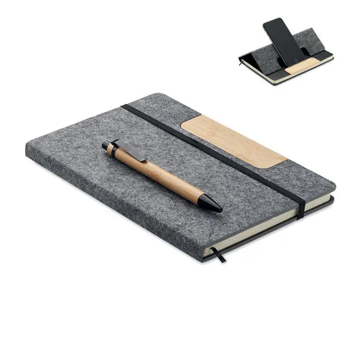 Set caiet A5 RPET gri din fetru cu insertie de lemn, banda elastica neagra si pix din bambus asezat deasupra
