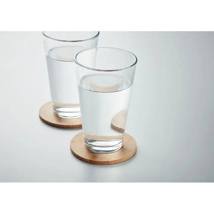Clear glass tumblers cu apă pe suporturi rotunde din bambus set de 6 suporturi din bambus